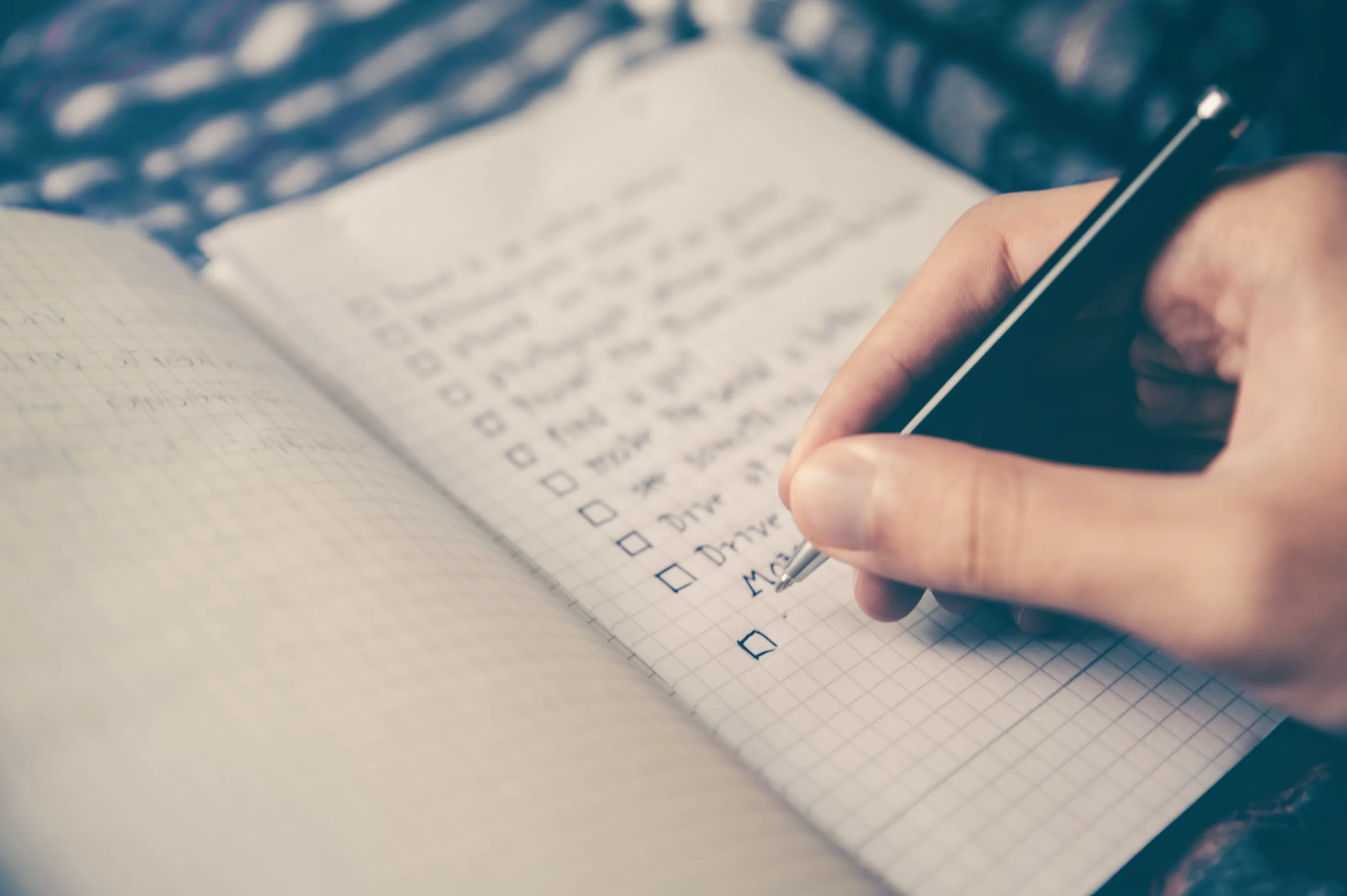 person filling out checklist in journal